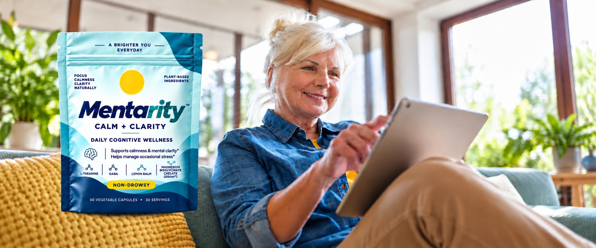 A silver-haired woman enjoying time on her tablet beside a Mentarity Calm + Clarity pouch